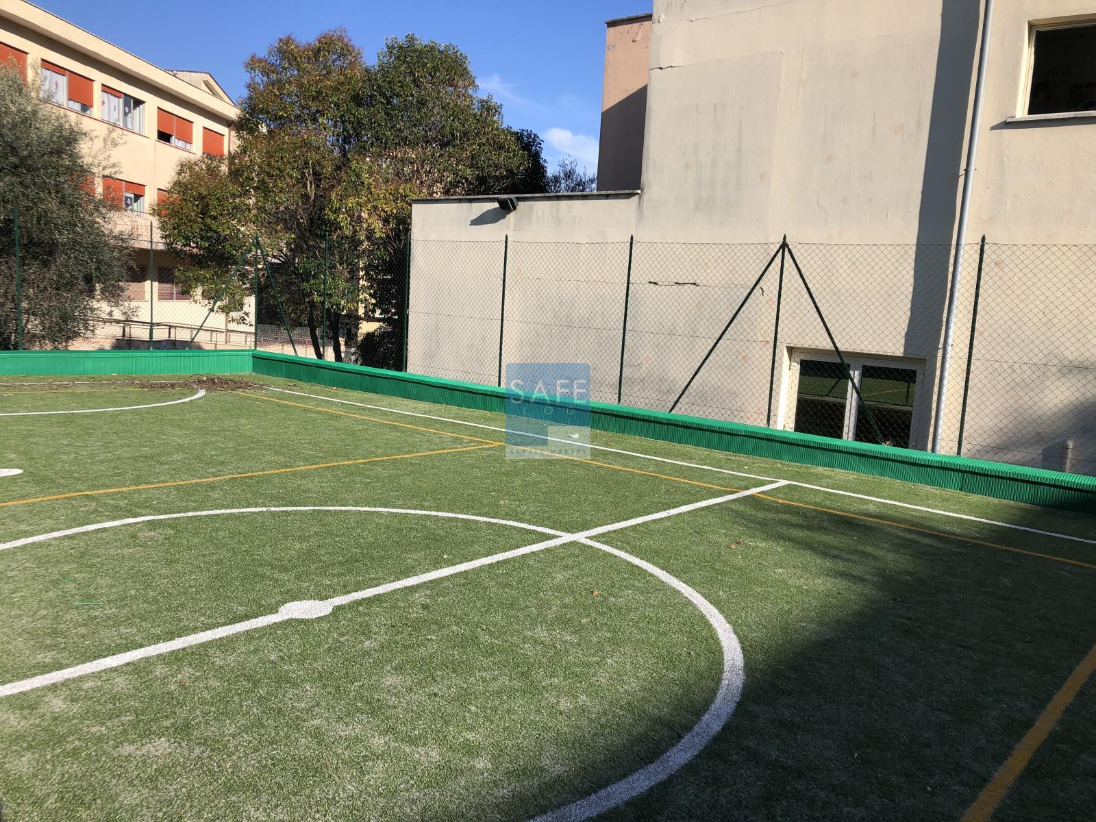 Pannelli in gomma antitrauma di colore verde applicati su cordolo perimetrale in cemento